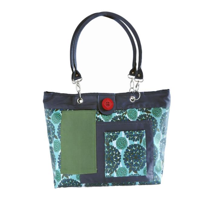 Floral fabric handbag with green patch and red button.